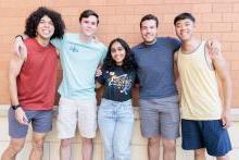 Diverse group of students standing together outside in front of a building on campus